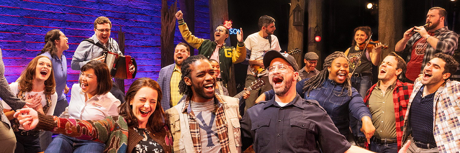 Men and women in present day clothing singing and playing instruments.